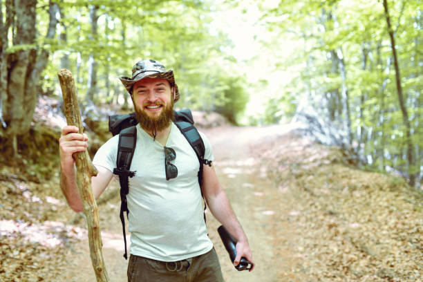 istock Bearded Mountaineer Smiling While Hiking On Footpath 1253830313