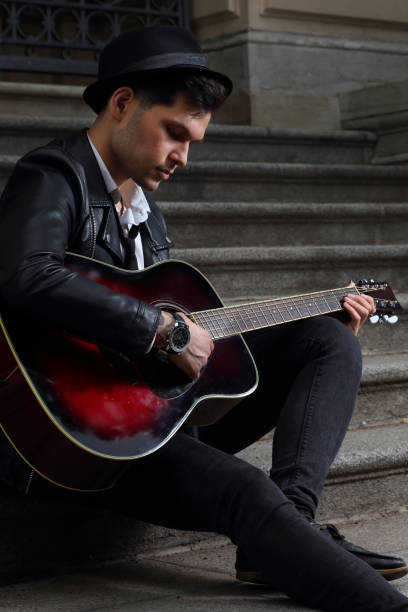 istock Guy with a guitar on the steps of a building 1253833193