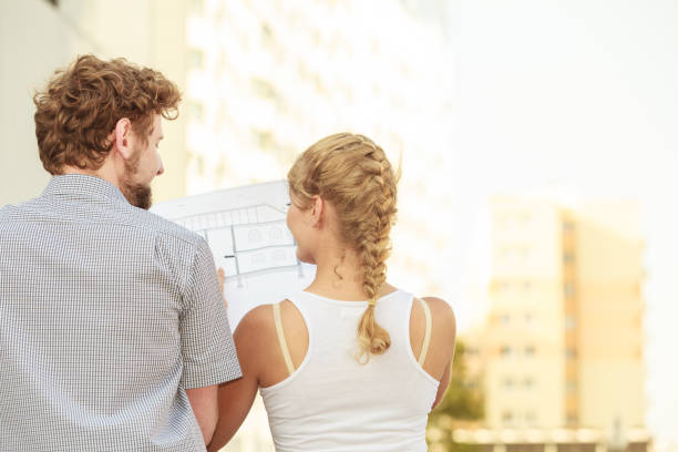 istock couple with blueprint project  building plans outdoor 1253833311