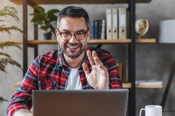 istock Middle aged man having video call from workplace at home 1253833870