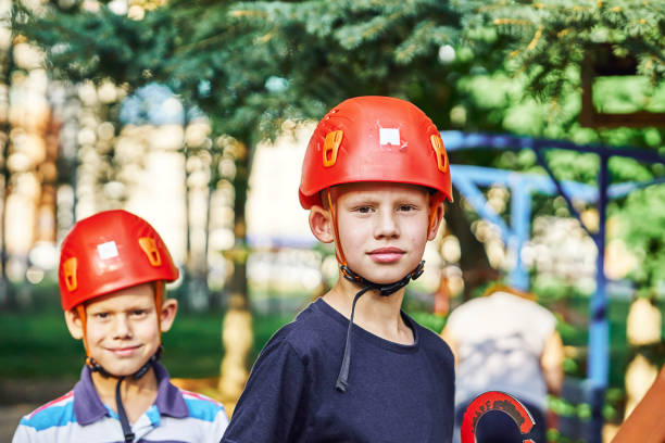 istock Two boys with climbing gear standing in rope park. No logo 1253834885