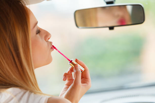 istock Woman applying makeup while driving her car 1253835810