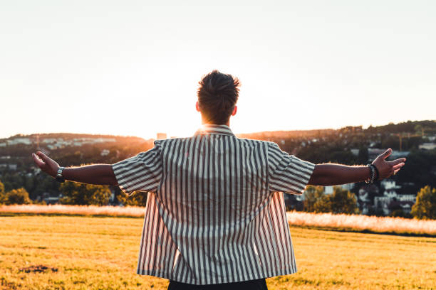 istock Freedom young man enjoying the sunset with open arms 1253836168