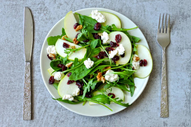 Apple salad with arugula, cottage cheese and dried cranberries. stock photo