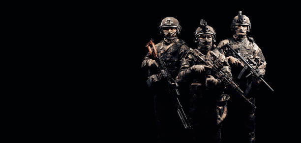 istock Three soldiers in uniform with a weapon in their hands are looking menacingly. 1253837754