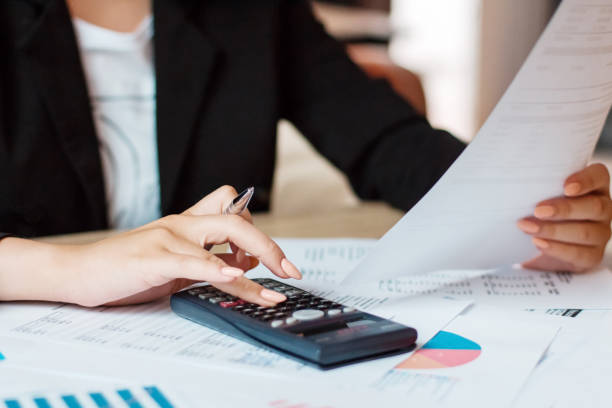 istock Businesswoman using a calculator to calculate the numbers 1253841221