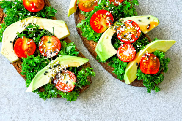 istock Toasts with avocado, cherry tomatoes and greens. 1253841301