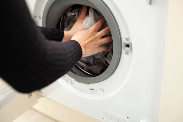 istock Close-up of bed sheets being loaded into washing machine 1253842277