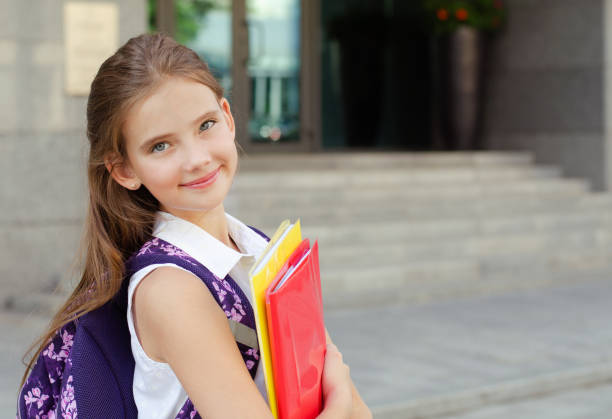 Back to school. Education concept. Cute smiling schoolgirl on the way to the schoo Back to school. Education concept. Cute smiling schoolgirl on the way to the school. Happy little girl child holding the books with backpack back to schoo stock pictures, royalty-free photos & images