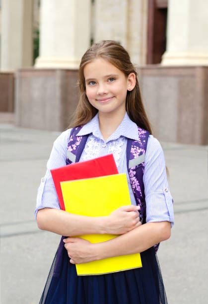 Back to school. Education concept. Cute smiling schoolgirl on the way to the schoo Back to school. Education concept. Cute smiling schoolgirl on the way to the school. Happy little girl child holding the books with backpack back to schoo stock pictures, royalty-free photos & images