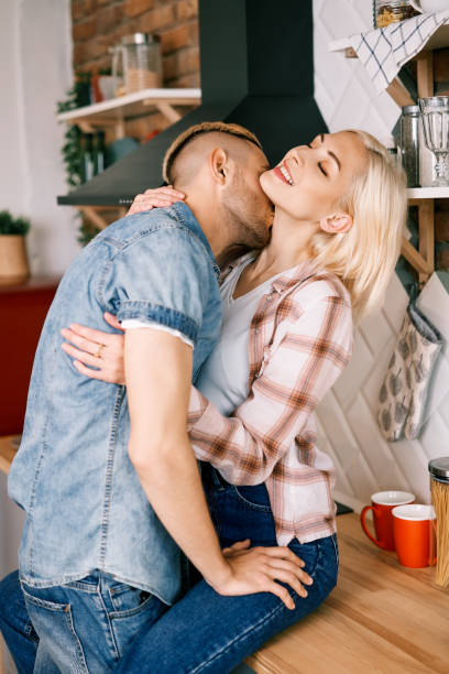 istock Passionate couple kissing in kitchen at home 1253842627