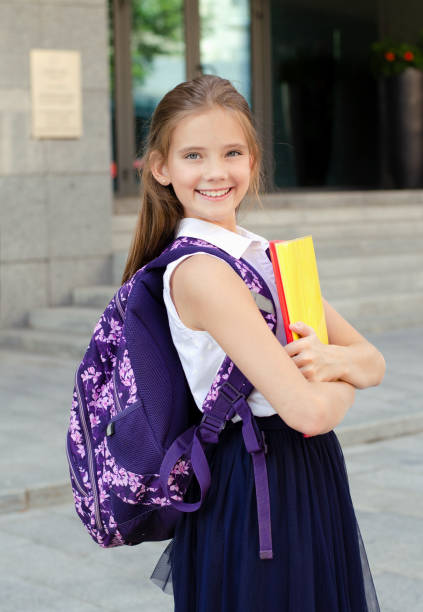 Back to school. Education concept. Cute smiling schoolgirl on the way to the schoo Back to school. Education concept. Cute smiling schoolgirl on the way to the school. Happy little girl child holding the books with backpack back to schoo stock pictures, royalty-free photos & images