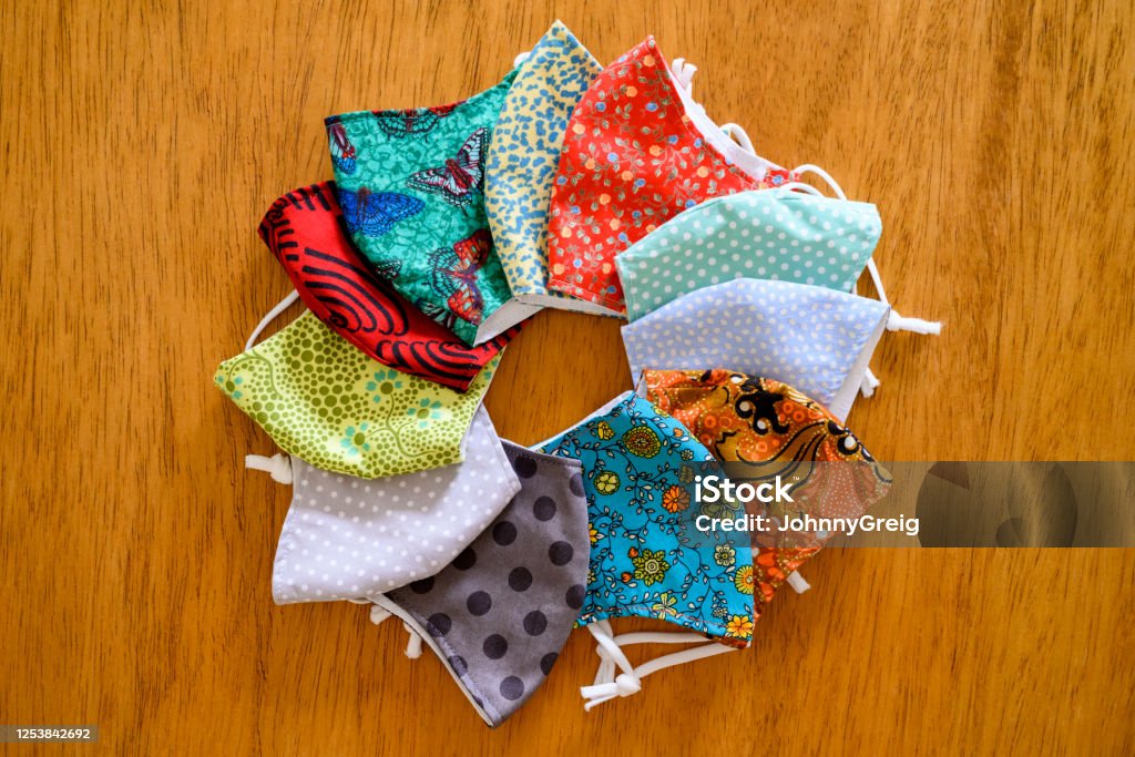 Homemade protective face masks with colourful fabrics Overhead view of hand made reusable covid-19 face masks. Still life. Protective Face Mask Stock Photo