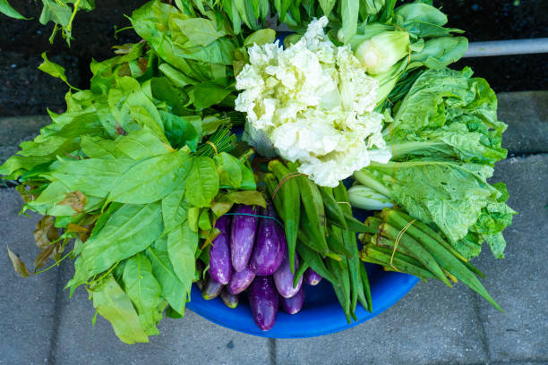 A counter with fresh vegetables and herbs in Asia. Street food.