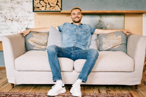 istock Handsome smiling man relax on sofa at home 1253842822