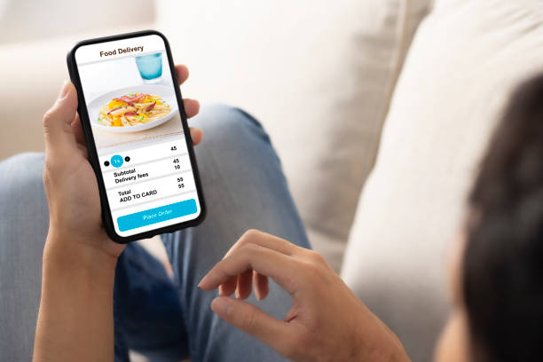 istock holding phone with application delivery food online 1253843647