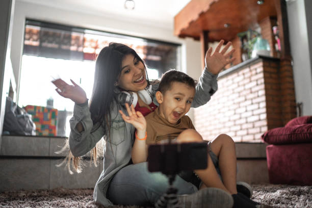 istock Sibling recording using mobile to a vlog or social media at home 1253845045