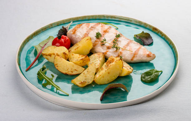 istock Grilled chicken fillet with fried potatoes. On light background 1253846377