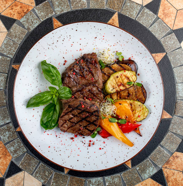 Grilled veal steak with vegetables and basil