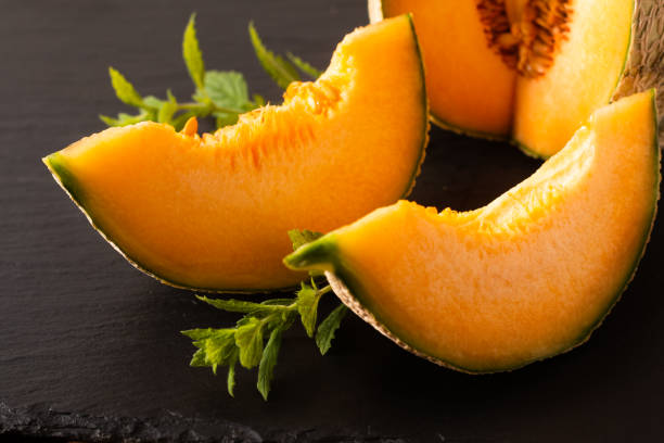 istock Summer food concept Melon fruit on black slate board with copy space 1253847449