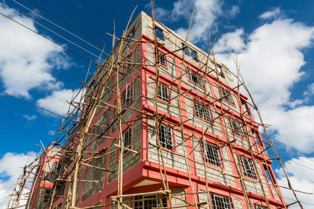 A small appartment building under construction with typical local scaffolding in the village of Tassia in Nairobi, Kenya.