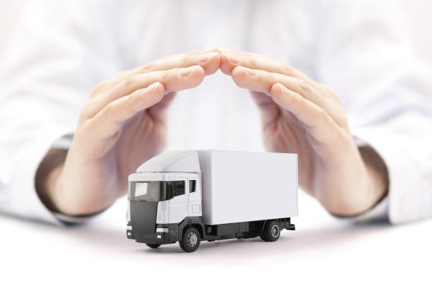 istock White cargo delivery truck miniature protected by hands 1253848406