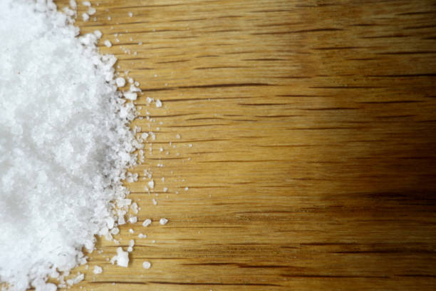 istock Sea salt on oak cuting board. 1253849946
