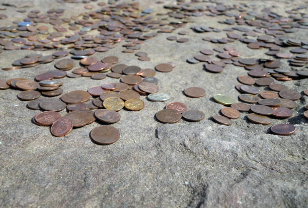 istock Metal coins on old stone symbolizm. 1253849970