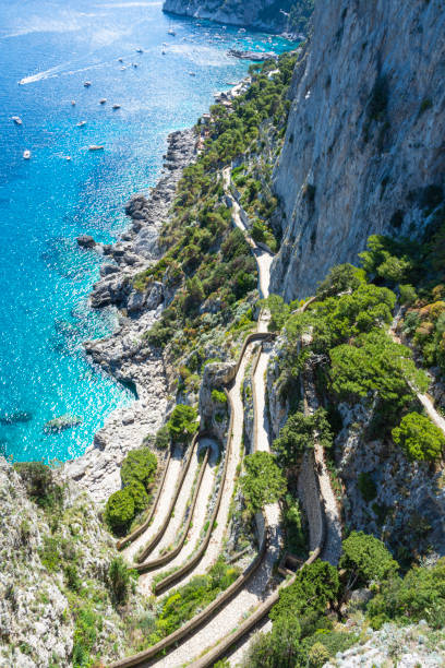 Beautiful sunny day at Via Krupp, on the coast of Mediterranean Sea - Capri Island ,Italy. Capri is an island located in the Tyrrhenian Sea off the Sorrento Peninsula, on the south side of the Gulf of Naples in the Campania region of Italy. The main town Capri that is located on the island shares the name. It has been a resort since the time of the Roman Republic. via krupp stock pictures, royalty-free photos & images