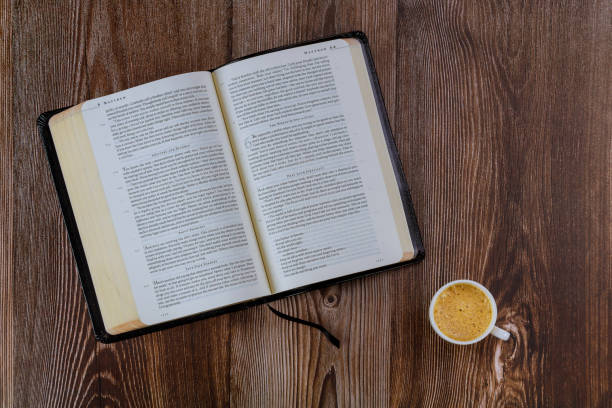 istock Open Bible morning readings on a table top with coffee cup 1253851276