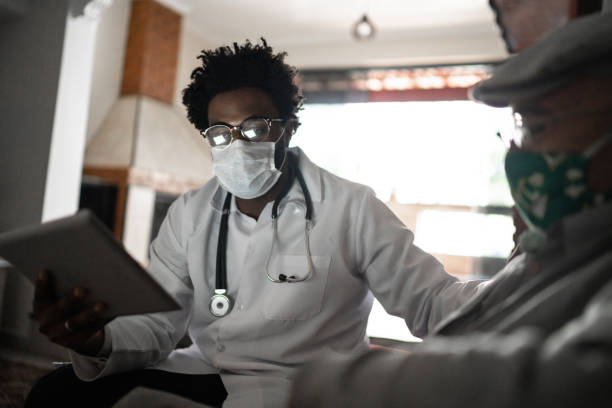 istock Doctor using digital tablet and talking to patient at home 1253852930