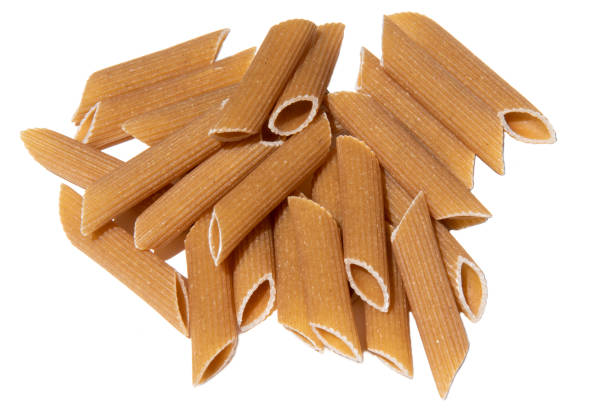 Pasta stack isolated on white. italian wholegrain penne lunch ingredient. healthy eating for vegetarian full of carbohydrate. uncooked grain mediterranean food. Heap of macaroni for healthy lifestyle. Pasta stack isolated on white. italian wholegrain penne lunch ingredient. healthy eating for vegetarian full of carbohydrate. uncooked grain mediterranean food. Heap of macaroni for healthy lifestyle. carbohydrate food type photos stock pictures, royalty-free photos & images