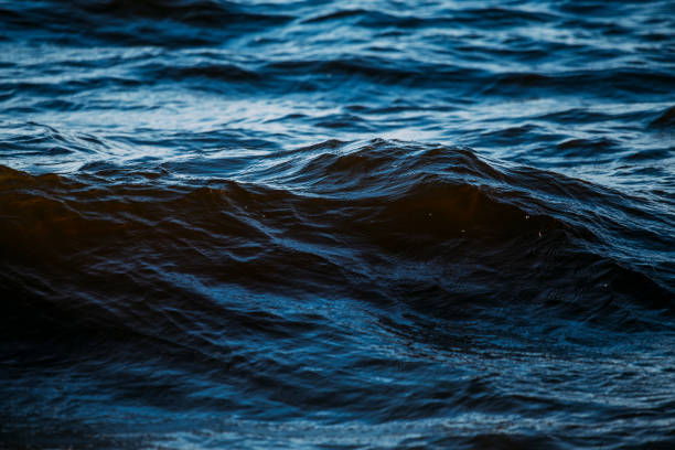 olas azules oscuras en el agua - mar fotografías e imágenes de stock