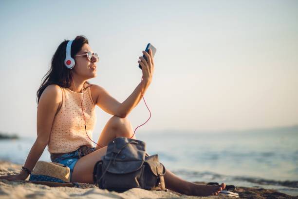 istock Woman at the beach making selfies 1253856022