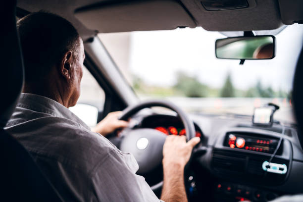 istock Senior man driving car 1253856323