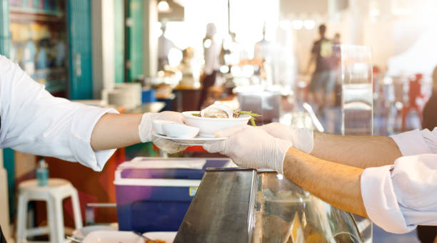 istock New Normal Restaurant table send to customer table with clean gloves 1253856341