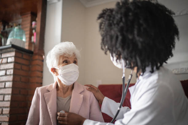istock Doctor using stethoscope on a senior patient at home 1253857717