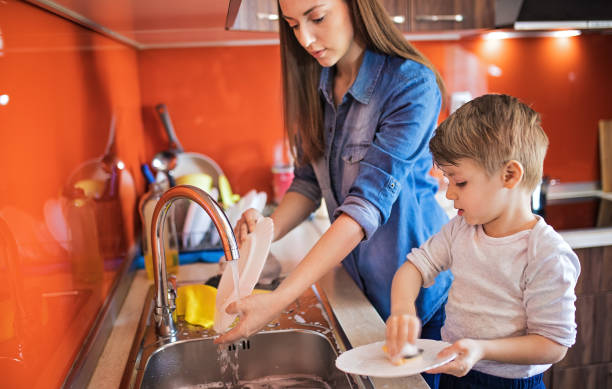 istock Mother and cute son doing the dishes 1253857743