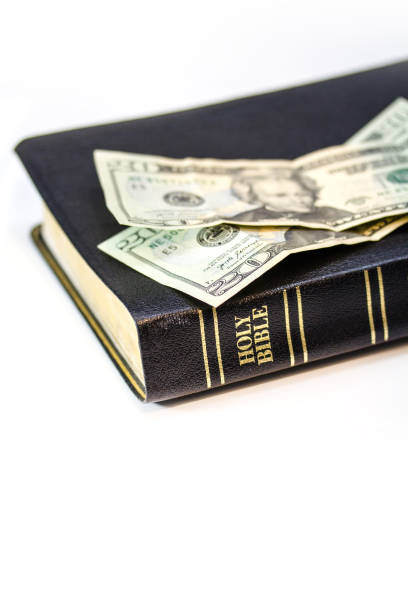 istock Holy Christian Bible with Money Isolated on White 1253857750