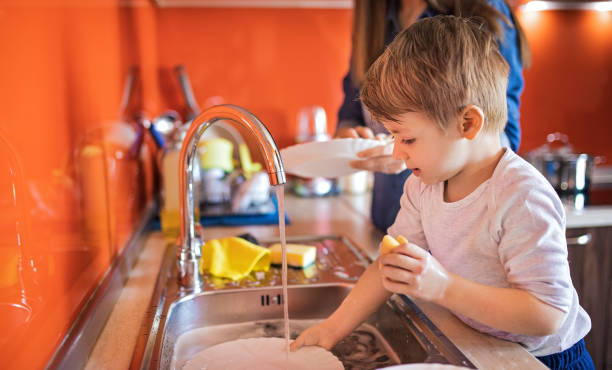 istock Mother and cute son doing the dishes together 1253857785