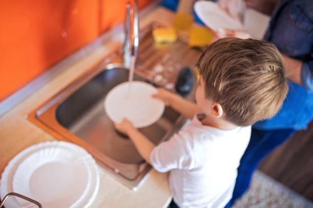 istock Mother and cute son doing the dishes together 1253857924