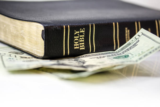 istock Holy Christian Bible with Money Isolated on White 1253857949