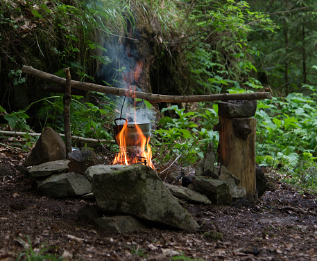 Camping kettle over burning campfire, Carpathian forest
