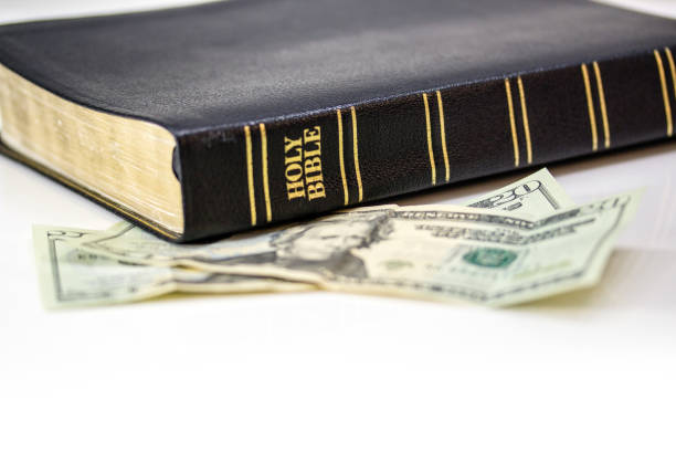 istock Holy Christian Bible with Money Isolated on White 1253858038