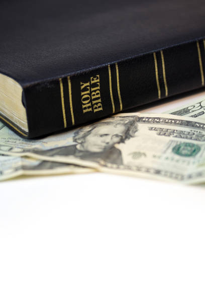 istock Holy Christian Bible with Money Isolated on White 1253858242