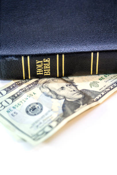 istock Holy Christian Bible with Money Isolated on White 1253858309