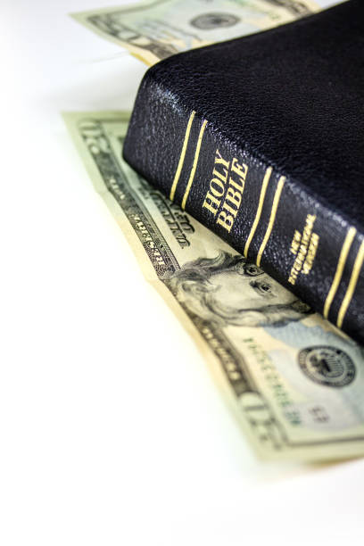 istock Holy Christian Bible with Money Isolated on White 1253859091