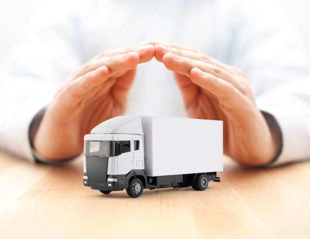 istock White cargo delivery truck miniature protected by hands 1253859519