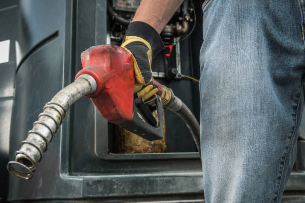 istock Trucker with Diesel Pump Nozzle in His Hand 1253859613