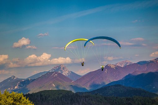 Flying paragliders from the Stranik hill over the mountainous landscape of the Zilina basin in the north of Slovakia.\nMala Fatra National Park in the background, Slovakia, Europe.
